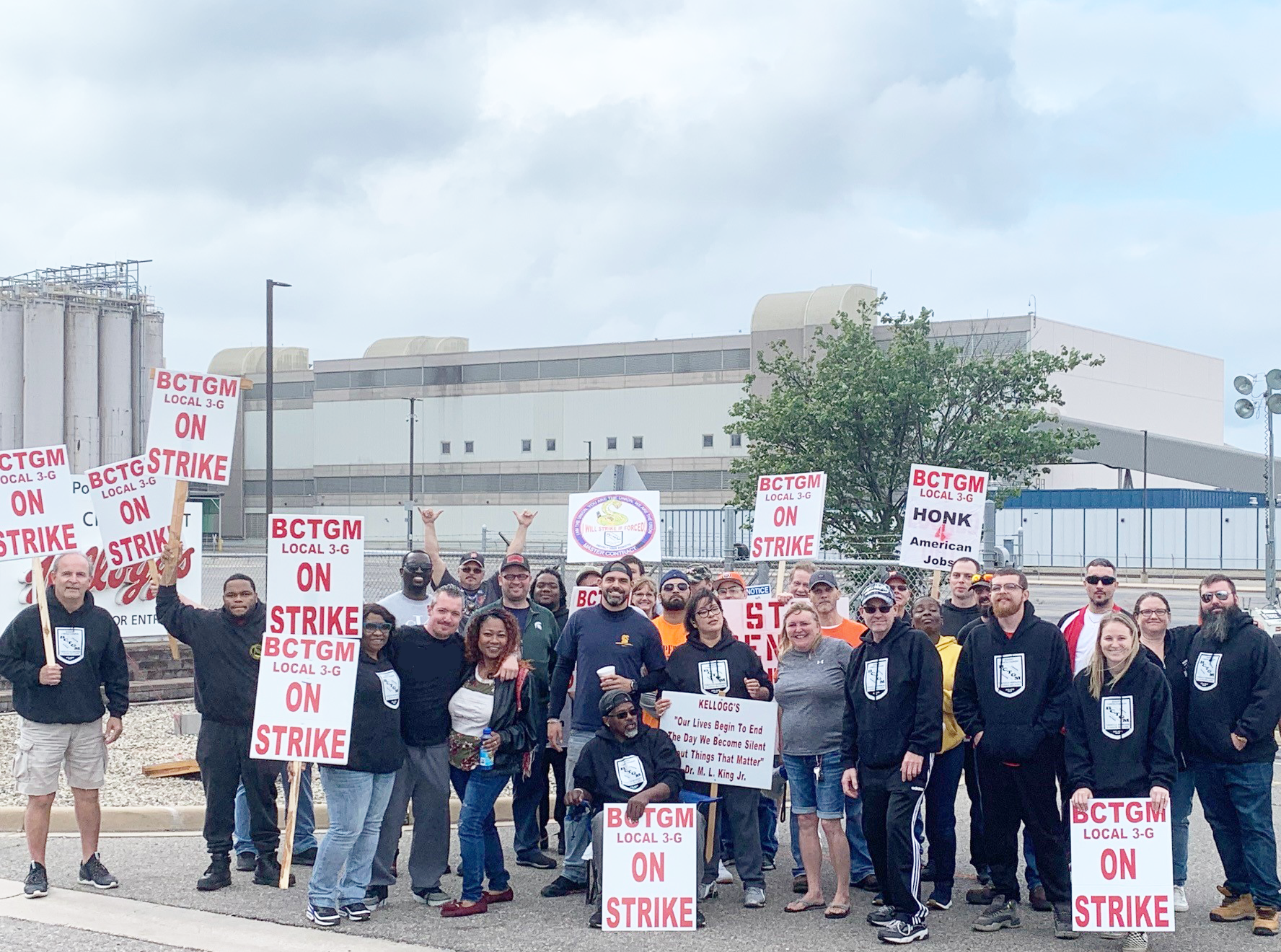 BCTGM Local 3-G Workers are seen holding signs in announcing and supporting their strike with the factory in the background.